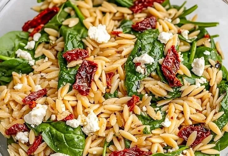 Colorful balsamic orzo salad with vegetables and dressing in a bowl