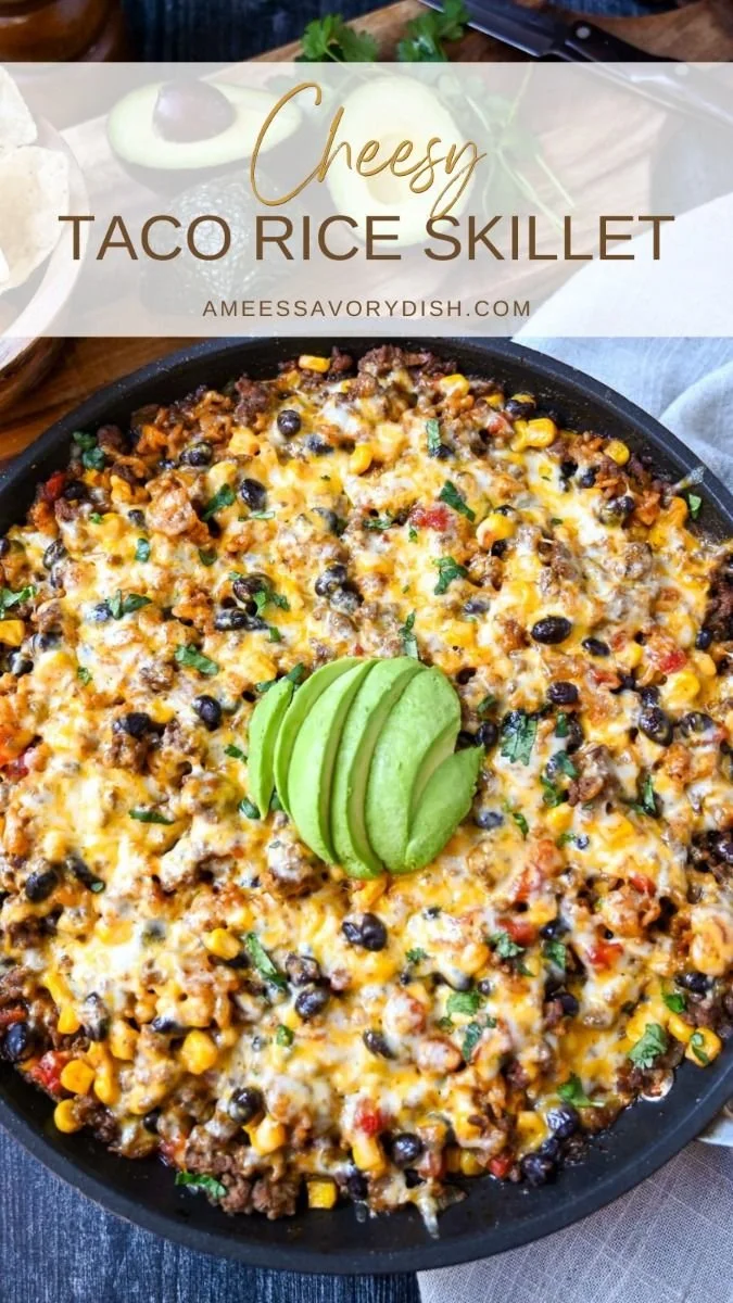 Cheesy taco rice skillet dish topped with cheese and fresh ingredients