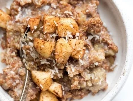 Cinnamon Apple Breakfast Quinoa served in a bowl with fresh apples and cinnamon