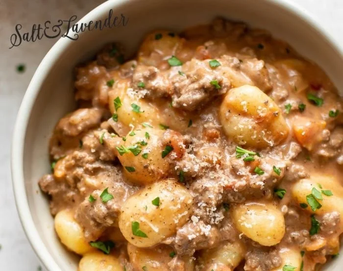 Creamy ground beef gnocchi served in a bowl with herbs