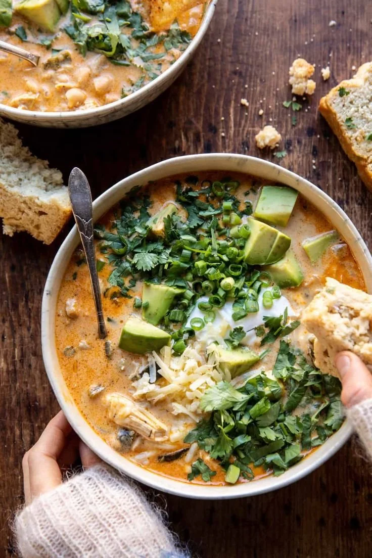 Bowl of creamy white chicken chili garnished with cilantro and lime slices.