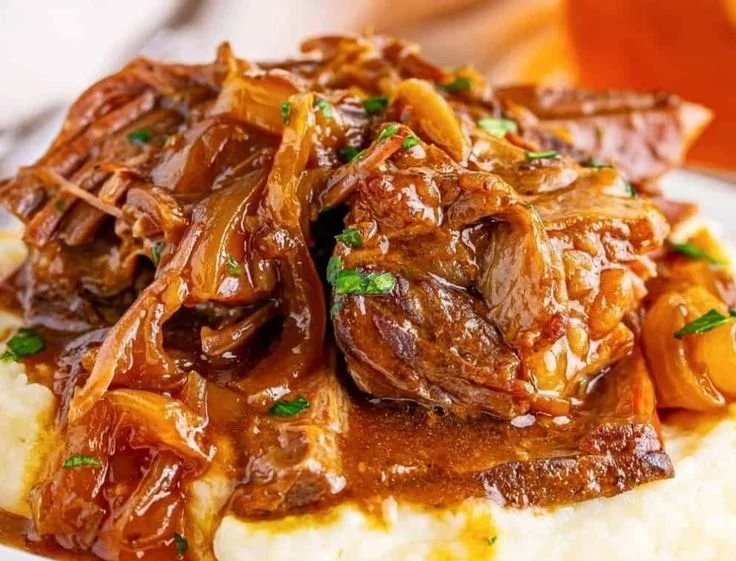 Delicious Crock Pot French Onion Pot Roast served with onions and herbs