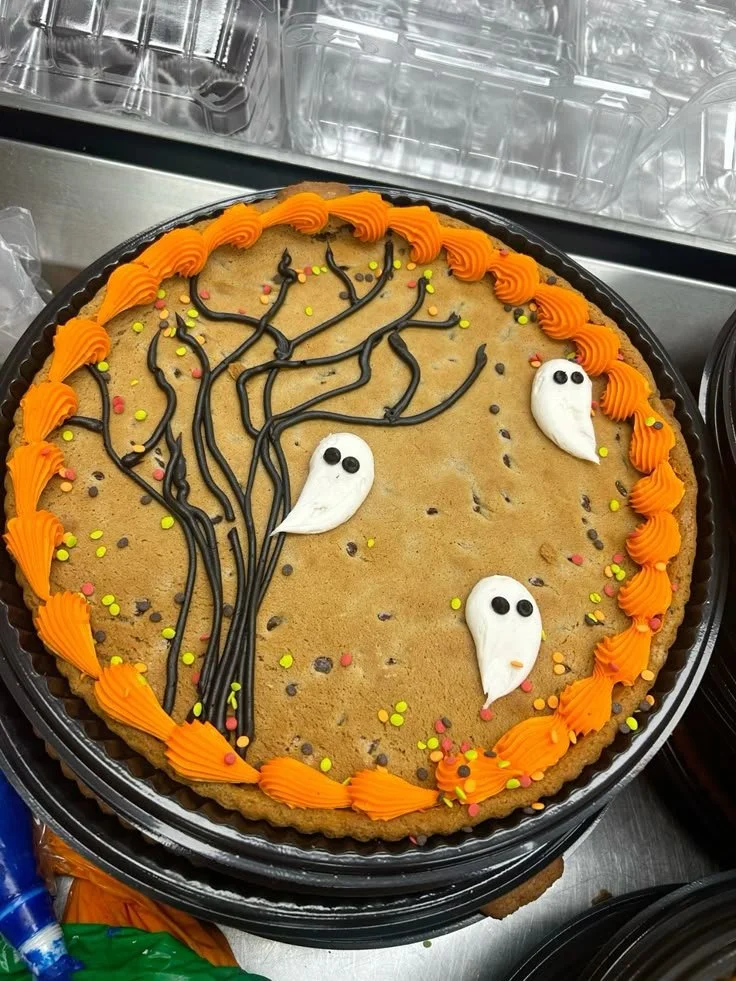 Halloween ghost cookie cake decorated with spooky ghost designs.