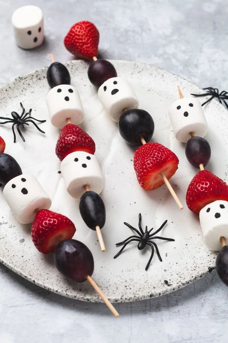 Colorful Halloween fruit skewers featuring spooky-themed designs
