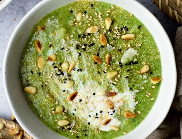 Healthy broccoli soup in a bowl with fresh ingredients garnished on top