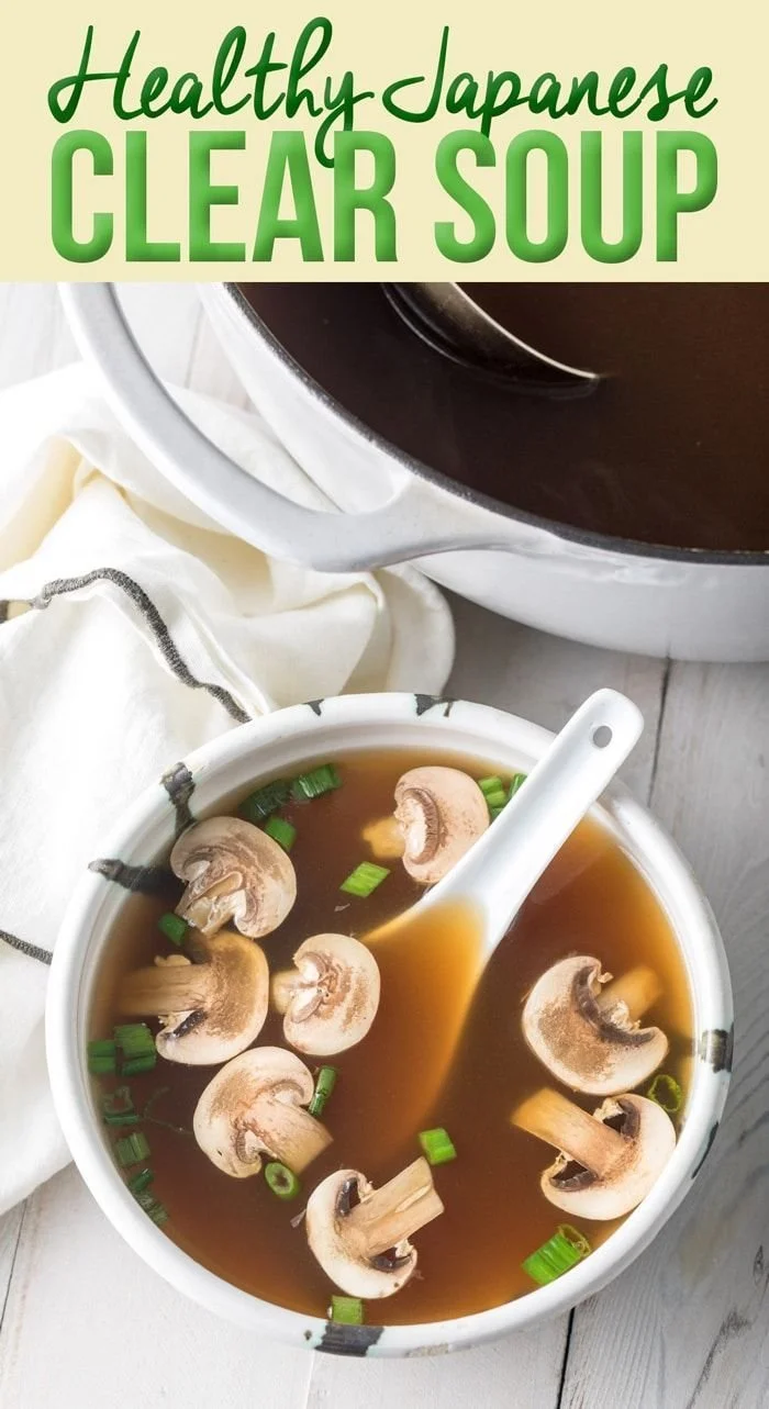 A bowl of Japanese clear soup garnished with green onions and mushrooms.