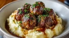 Salisbury steak meatballs served with garlic herb mashed potatoes on a plate