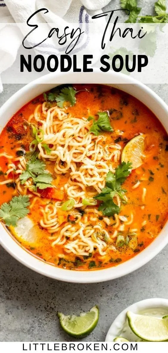 Bowl of Thai red curry noodle soup with herbs and vegetables
